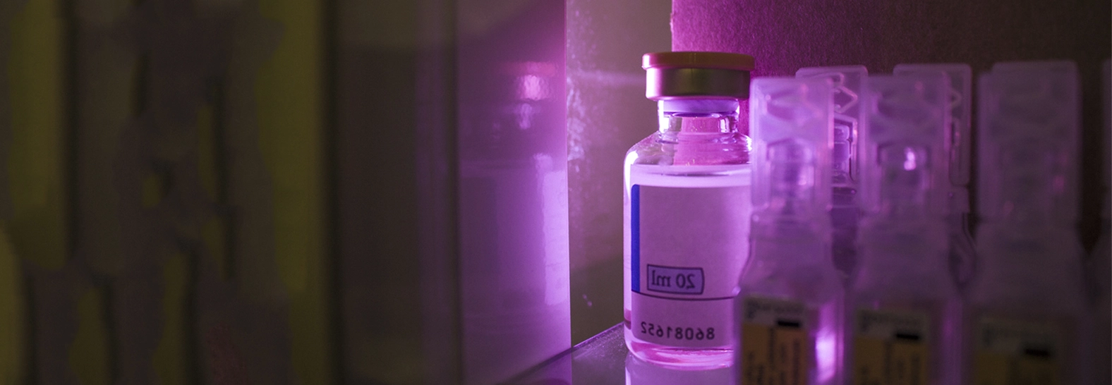 Mała butelka z płynem oświetlona fioletowym światłem LED